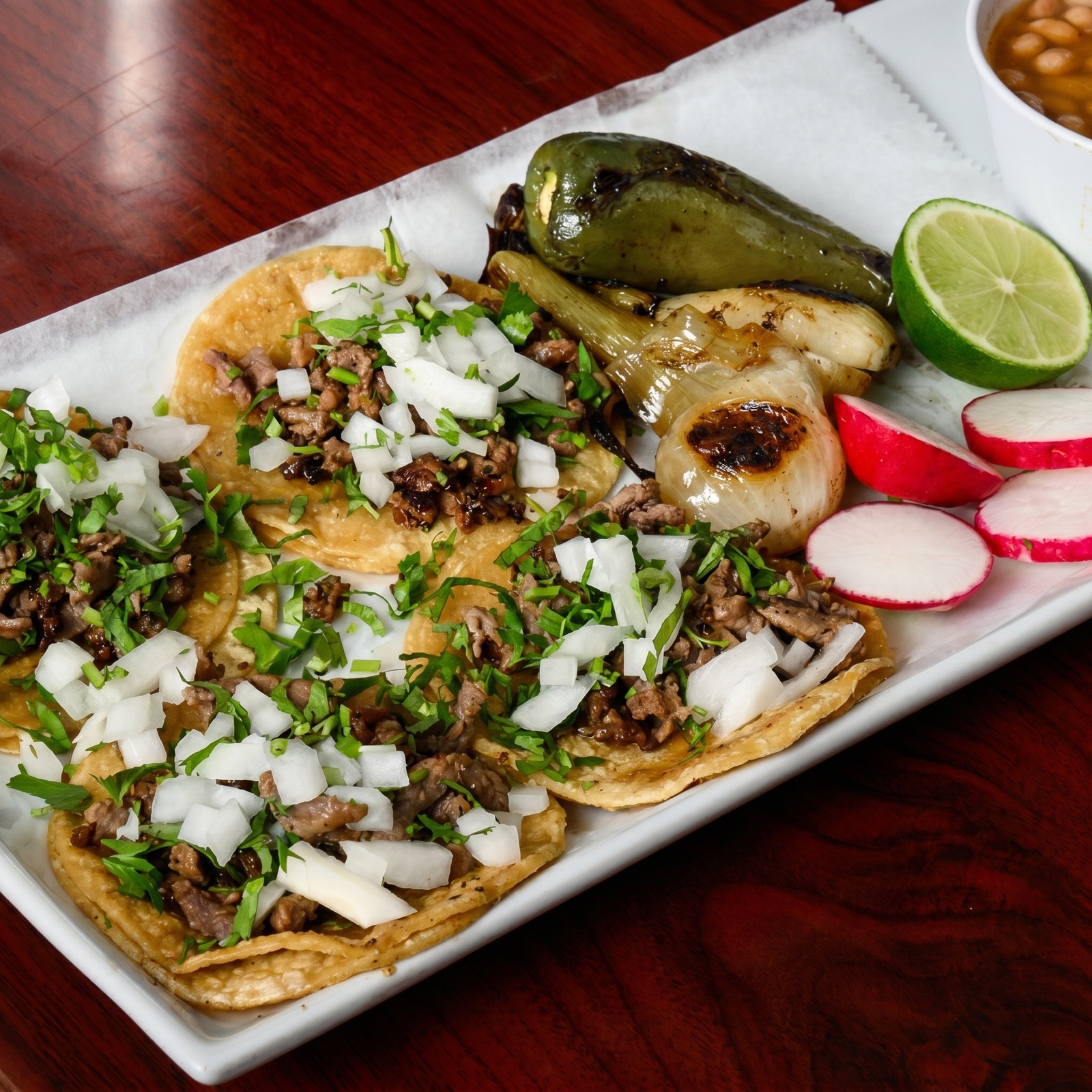 Tacos mexicanos con cebolla, cilantro y rábano